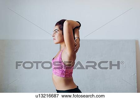 Stock Photo - Woman doing stretching exercise at home. Fotosearch