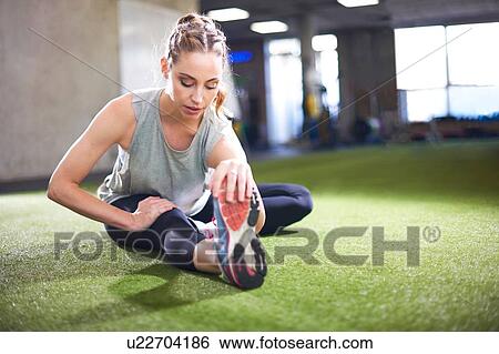 Woman doing stretching exercise in gym View Large Photo Image Stock Photograph - Woman doing stretching exercise in gym. Fotosearch