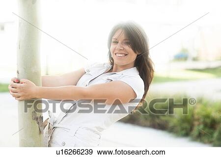 Woman hanging onto tree View Large Photo Image Stock Photo - Woman hanging onto tree. Fotosearch