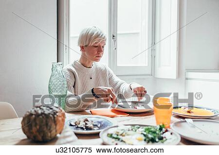 Stock Photography - Woman having lunch at home. Fotosearch