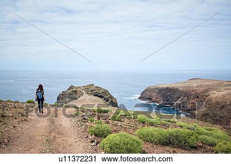 Woman hiking on coastal dirt track, Las Palmas, Gran Canaria, Canary Islands, Spain View Large Photo Image Stock Image - Woman hiking on coastal dirt track, Las Palmas, Gran Canaria, Canary Islands, Spain. Fotosearch