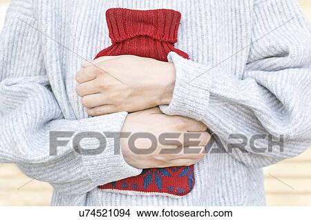 Picture - Woman holding hot water bottle. Fotosearch