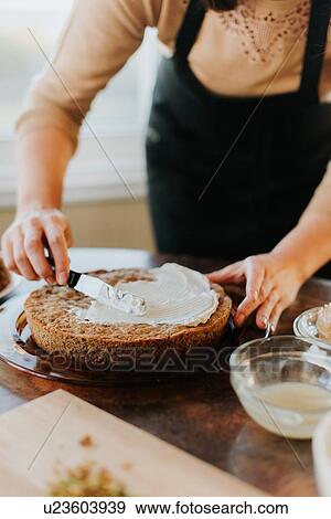 Stock Photo - Woman in apron baking vegetarian cake. Fotosearch