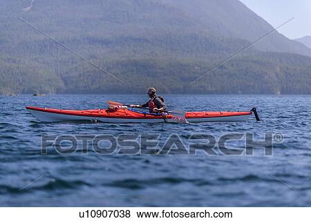 Stock Photo - Woman kayaking in lake, Johnstone Strait, Telegraph Cove, Canada. Fotosearch