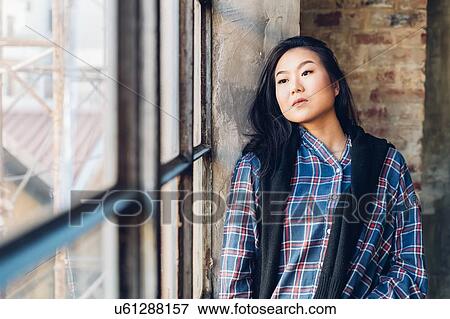 Woman leaning against brick wall by window View Large Photo Image Stock Photo - Woman leaning against brick wall by window. Fotosearch