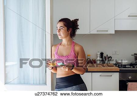 Woman leaning against kitchen door View Large Photo Image Stock Image - Woman leaning against kitchen door. Fotosearch