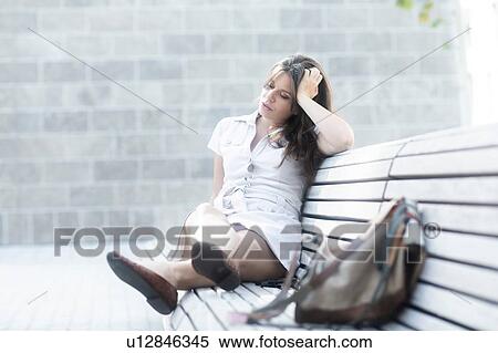 Stock Photography - Woman on bench looking tired. Fotosearch