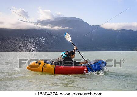 Picture - Woman packrafting, Howe Sound bay, Squamish, Canada. Fotosearch