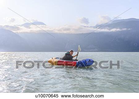 Stock Photography - Woman packrafting, Howe Sound bay, Squamish, Canada. Fotosearch