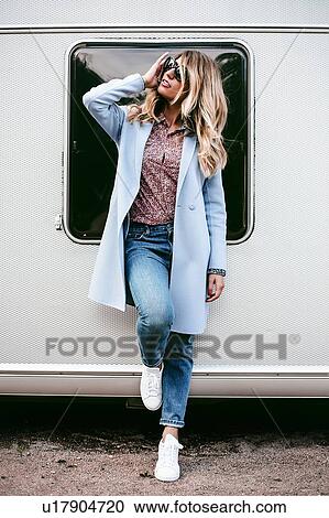 Stock Image - Woman posing near trailer. Fotosearch