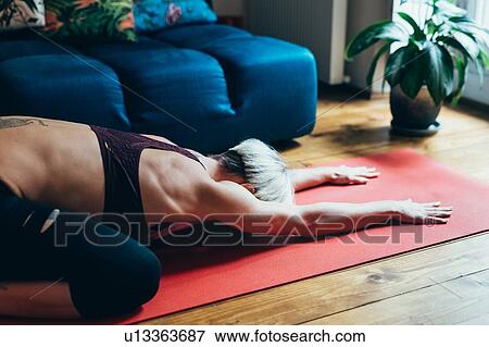 Woman practising yoga at home View Large Photo Image Stock Photo - Woman practising yoga at home. Fotosearch
