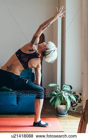 Woman practising yoga at home View Large Photo Image Stock Photo - Woman practising yoga at home. Fotosearch