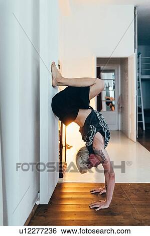 Stock Photograph - Woman practising yoga at home. Fotosearch