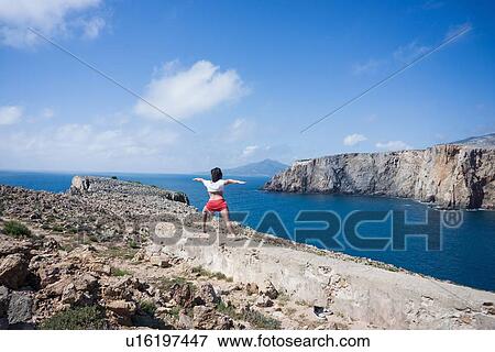 Stock Photo - Woman practising yoga on hilltop, Iglesias, Sardinia, Italy. Fotosearch