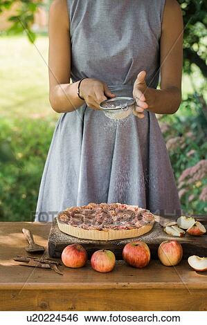 Stock Photograph - Woman preparing apple pie on table. Fotosearch