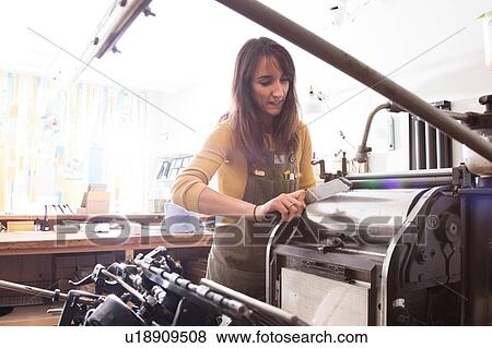 Stock Photo - Woman preparing printer in shop. Fotosearch