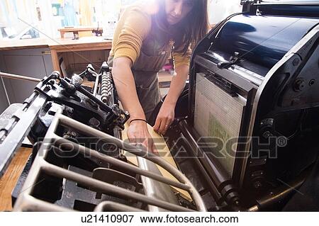 Stock Photo - Woman preparing printer in shop. Fotosearch