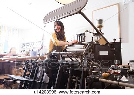 Stock Photograph - Woman preparing printer in shop. Fotosearch