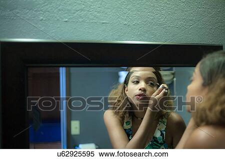 Stock Photography - Woman putting on make up. Fotosearch