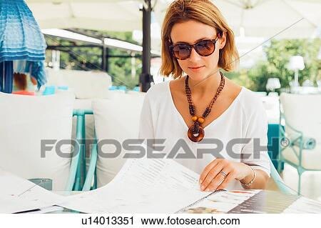 Woman reading menu on terrace View Large Photo Image Stock Image - Woman reading menu on terrace. Fotosearch