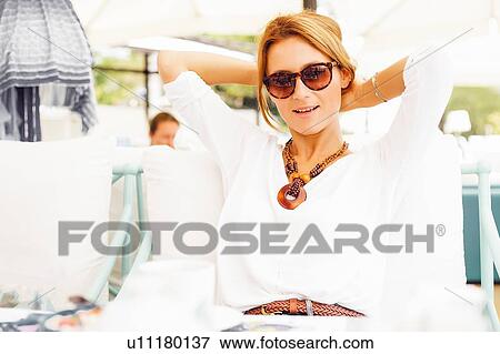 Stock Photo - Woman relaxing on terrace. Fotosearch