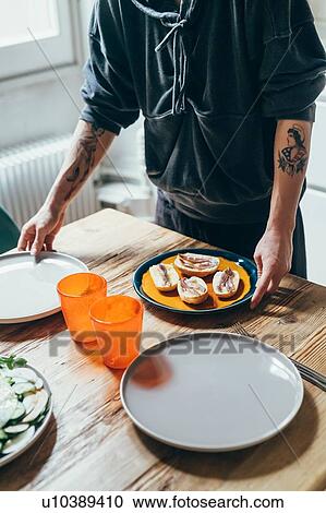 Woman setting table in kitchen View Large Photo Image Stock Image - Woman setting table in kitchen. Fotosearch