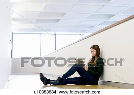 Woman sitting on floor using digital tablet View Large Photo Image Picture - Woman sitting on floor using digital tablet. Fotosearch
