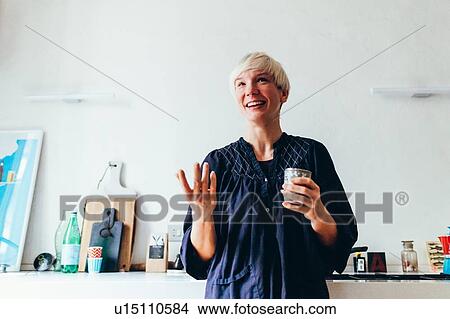 Picture - Woman smiling in kitchen. Fotosearch