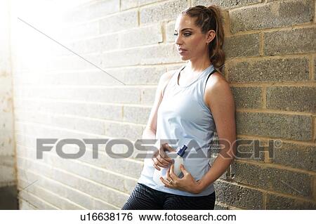 Stock Photograph - Woman taking break in gym. Fotosearch