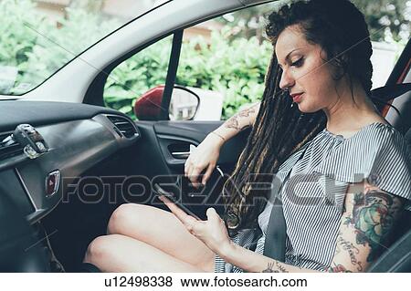 Stock Photo - Woman using mobile phone in car. Fotosearch