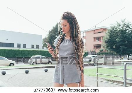 Stock Photo - Woman using mobile phone in park. Fotosearch