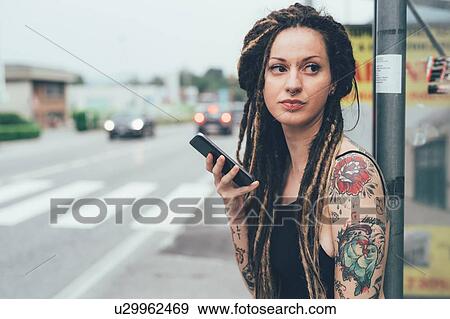 Stock Photo - Woman using mobile phone on roadside. Fotosearch