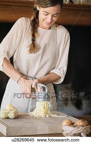 Woman using potato ricer to prepare gnocchi View Large Photo Image Stock Photography - Woman using potato ricer to prepare gnocchi. Fotosearch