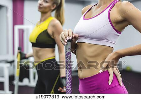 Stock Photo - Woman wearing cropped sports top with hand on hip. Fotosearch