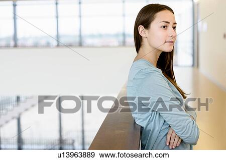 Woman with arms crossed leaning on low wall View Large Photo Image Stock Photo - Woman with arms crossed leaning on low wall. Fotosearch