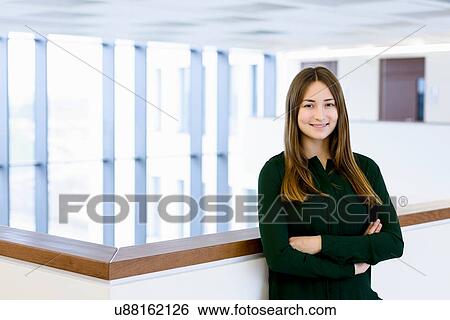 Woman with arms crossed leaning on low wall View Large Photo Image Stock Photograph - Woman with arms crossed leaning on low wall. Fotosearch