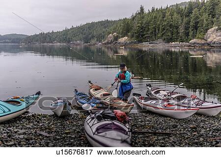 Woman with sea kayaks on lakeside, Johnstone Strait, Telegraph Cove, Canada View Large Photo Image Stock Photo - Woman with sea kayaks on lakeside, Johnstone Strait, Telegraph Cove, Canada. Fotosearch