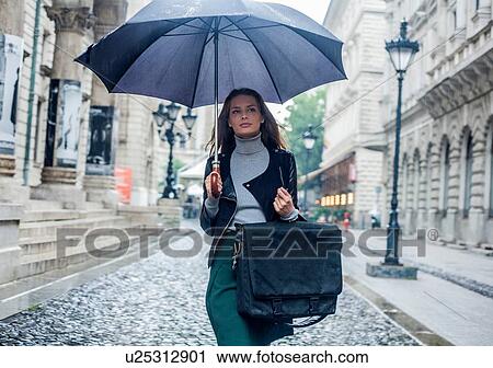 Woman with umbrella on morning commute, Budapest, Hungary View Large Photo Image Stock Image - Woman with umbrella on morning commute, Budapest, Hungary. Fotosearch