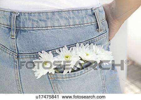 Stock Image - Woman with white flowers in back pocket. Fotosearch