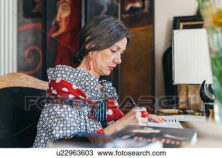 Stock Image - Woman working on designs in her studio. Fotosearch