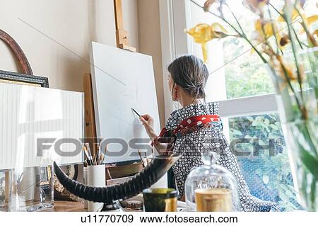 Woman working on designs in her studio View Large Photo Image Stock Photo - Woman working on designs in her studio. Fotosearch