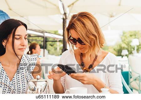 Stock Photo - Women having tea on terrace. Fotosearch
