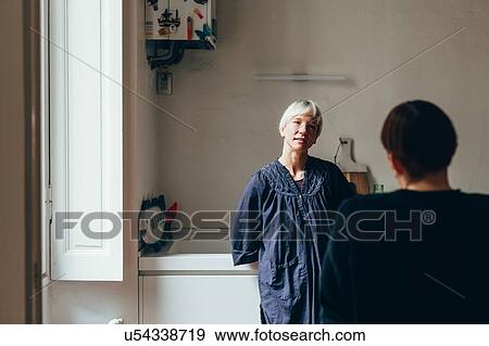 Stock Photo - Women talking in kitchen. Fotosearch