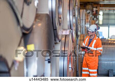Worker using digital tablet by rows of sheet steel in storage at port View Large Photo Image Stock Photography - Worker using digital tablet by rows of sheet steel in storage at port. Fotosearch