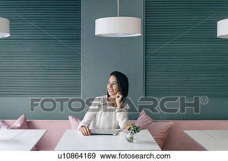Young businesswoman at hotel table looking away View Large Photo Image Stock Photo - Young businesswoman at hotel table looking away. Fotosearch