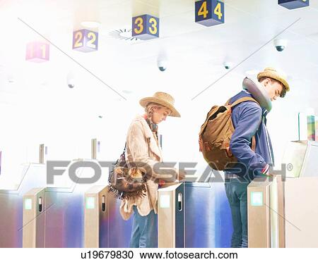 Young couple at airport, carrying backpacks, walking through turnstiles View Large Photo Image Stock Image - Young couple at airport, carrying backpacks, walking through turnstiles. Fotosearch