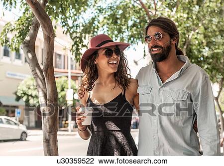 Stock Image - Young couple talking and laughing outdoors. Fotosearch