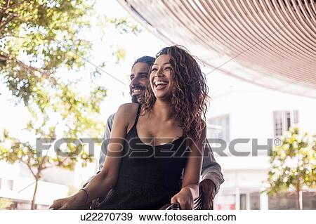 Stock Photo - Young couple talking and laughing outdoors. Fotosearch