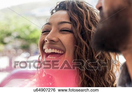 Stock Photograph - Young couple talking and laughing outdoors. Fotosearch