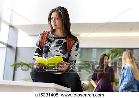 Young female university student reading book in university lobby View Large Photo Image Stock Photography - Young female university student reading book in university lobby. Fotosearch
